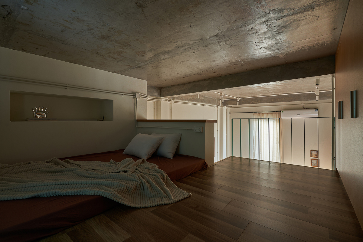 Gác lửng là không gian nghỉ ngơi riêng tư. Vì diện tích trần thấp, phương án được chọn là lát sàn gỗ và kê nệm trực tiếp thay vì làm giường.